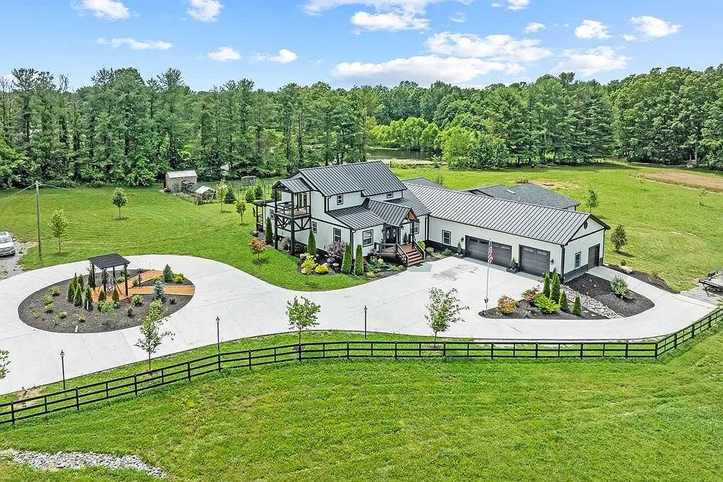 Aerial returning to the full property, this time with the surrounding forest visible at the perimeter and the option to acquire 27 additional adjacent acres.